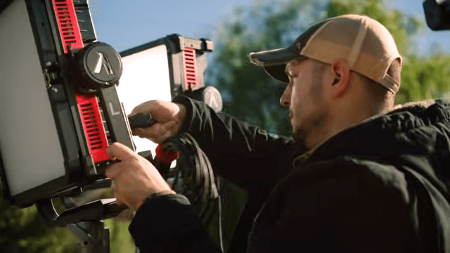 A professional gaffer adjusting the Aputure NOVA 9° LED panel light, showcasing its rugged build and the Extended Range BLAIR-CG engine designed for 2026 digital sensors.
