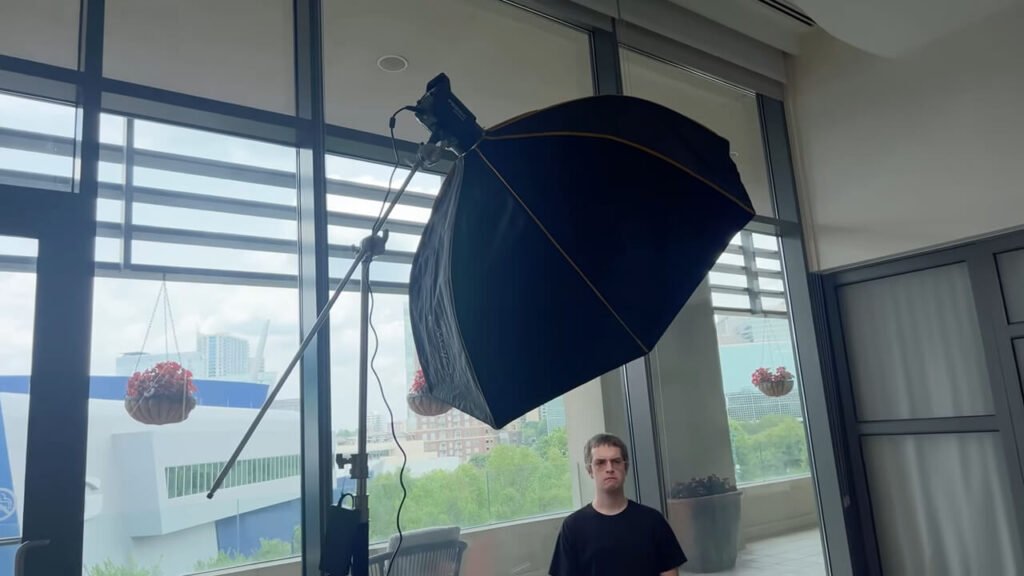 Hand adjusting control knobs on the rear panel of the red GVM PRO SD300C video light.