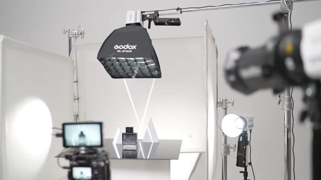 A detailed section of the guide exploring professional cinema power, featuring a close-up of a godox video light assembly and expert gaffer Andrew Lock demonstrating a Godox Knowled series fixture.