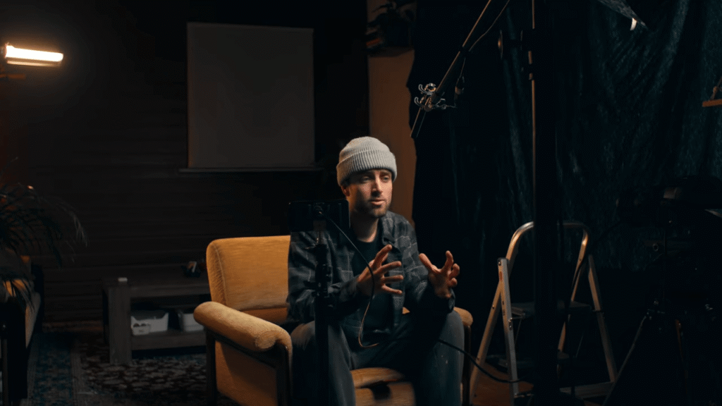Cinematic recording studio lighting featuring a moody close-up of a music producer to illustrate the "visual stage" of modern audio production.