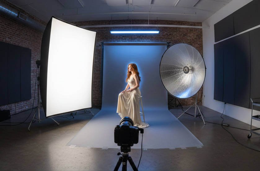 Professional 3-point lighting setup with softbox and C-stands in a studio.
