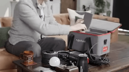 A gaffer is unboxing the Aputure STORM 80c.